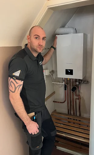 Emergency Plumber engineer beside a fitted boiler